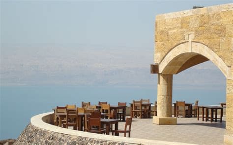 The Panorama restaurant terrace under a stone arch, looking out over the Dead Sea