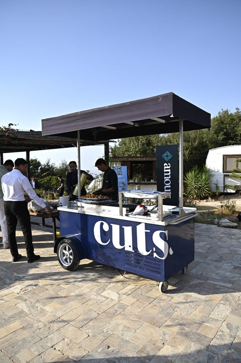 Guests queue at a food truck on the grounds in the afternoon light.